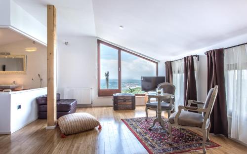 a living room with a table and chairs and a large window at villa Storia in Dobrinj
