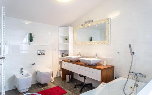 a white bathroom with two sinks and a mirror at villa Storia in Dobrinj