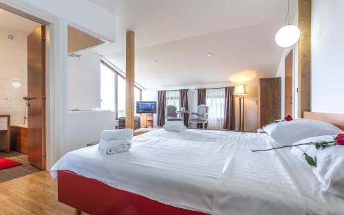 a large white bed with two white towels on it at villa Storia in Dobrinj