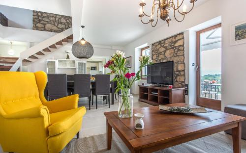 a living room with a yellow chair and a table at villa Storia in Dobrinj