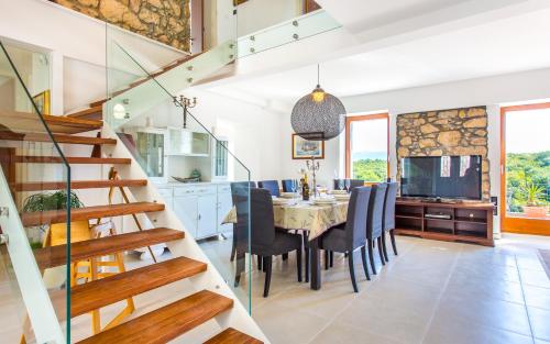 a dining room and kitchen with a table and chairs at villa Storia in Dobrinj