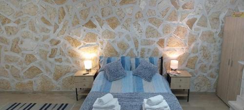 a bedroom with a bed and two night stands with lamps at Lovely Studio in Strinilas with its own pool in StrinÃ½las