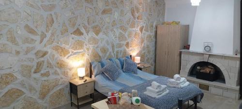 a bedroom with a bed and a stone wall at Lovely Studio in Strinilas with its own pool in StrinÃ½las