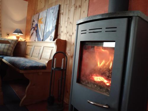 a fireplace in a living room with a fire in it at Karlbauer Hütte in Lendorf