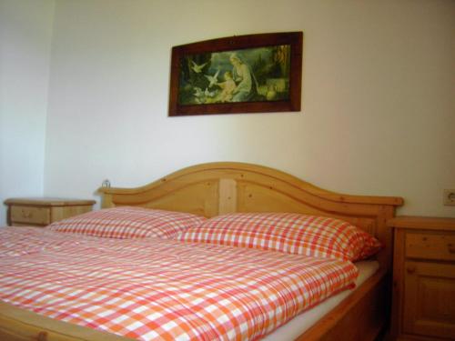 a bed with two pillows and a picture on the wall at Karlbauer Hütte in Lendorf