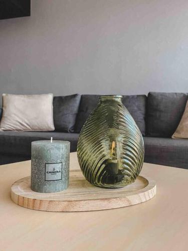 eine Kerze und eine Vase auf einem Tisch im Wohnzimmer in der Unterkunft Appartement coconing , parking privé, climatisation & WIFI in Montpellier