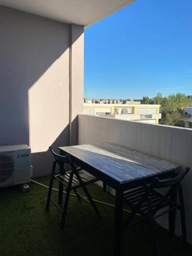 einen Picknicktisch und zwei Stühle auf dem Balkon in der Unterkunft Appartement coconing , parking privé, climatisation & WIFI in Montpellier