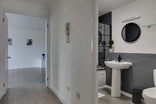 ein Badezimmer mit einem Waschbecken, einem WC und einem Spiegel in der Unterkunft Entire home/flat perfect for contractors in Bishops Stortford