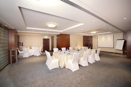 a conference room with white tables and white chairs at Raviz Center Point Hotel in Dubai