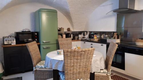 uma cozinha com uma mesa e um frigorífico verde em duplex vieille ville, à partager avec 2 chats em Briançon