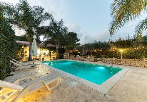 a swimming pool with lounge chairs and a resort at Case Vacanze la fenice- Casa Mediterranea in Cava dʼAliga
