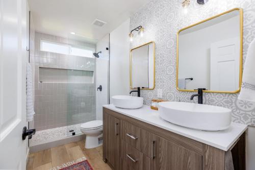 een witte badkamer met 2 wastafels en een toilet bij Los Tres Coyotes in Twentynine Palms
