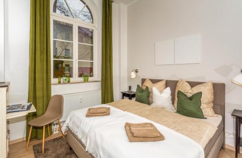 ein Schlafzimmer mit einem großen Bett mit grünen Akzenten in der Unterkunft Apartment Westend in Markranstädt