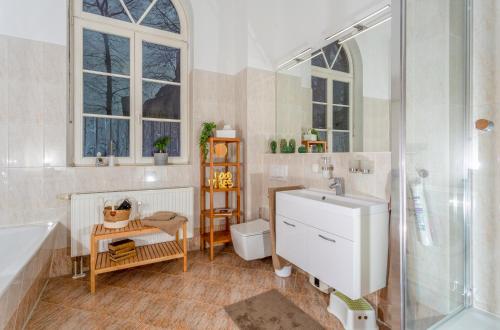 uma casa de banho com uma banheira, um lavatório e um WC. em Apartment Westend em Markranstädt