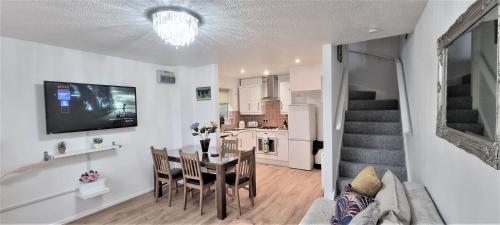 a living room with a table and a kitchen at Waterfront - Holes Bay, Poole, Dorset in Hamworthy