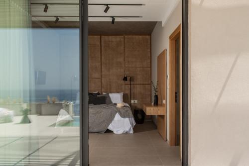 a bedroom with a bed and a sliding glass door at Limnionas Infinity Cave Villa in Kampíon