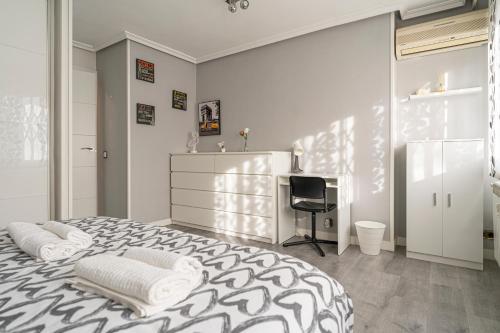 um quarto branco com uma cama e uma secretária em Bonito, Práctico y muy bien comunicado em Madri
