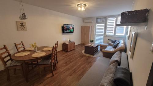 a living room with a table and a couch at Sflower Apartman in Eger