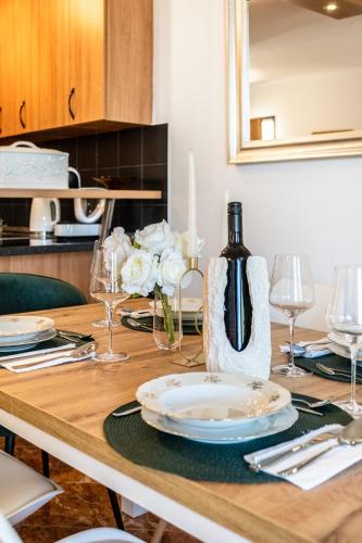 a dining room table with a bottle of wine and glasses at Apartment Mia in Sutivan