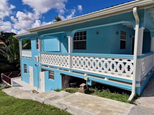 a blue house with a white balcony at My Gem in the Caribbean in Castries