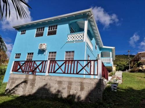a blue house with a balcony on top of it at My Gem in the Caribbean in Castries