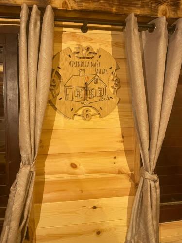 a wooden clock on a wooden wall with curtains at Family home MASA in Žabljak