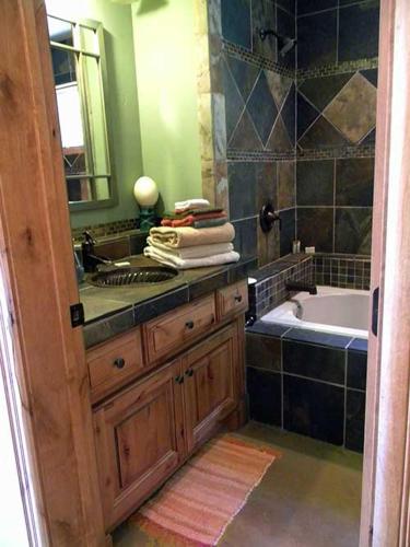 a bathroom with a sink and a tub and a mirror at Talus Rock Retreat in Sandpoint
