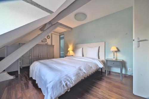 - une chambre avec un grand lit blanc et un escalier dans l'établissement La tête d'Or, UnSéjouràMetz, à Metz