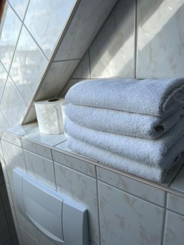 een stapel handdoeken op een plank in een badkamer bij H&H Studio-Apartments im Zentrum jedes Apartment mit Küchenzeilen - 24h Check In in Greifswald