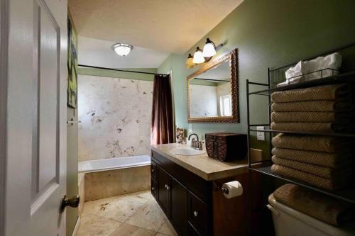 a bathroom with a sink and a tub and a mirror at Luxurious 5 bedroom w pool table in Redmond