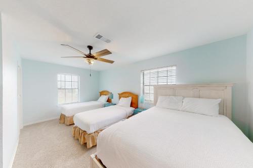 a bedroom with two beds and a ceiling fan at A Pirate's Paradise in Galveston