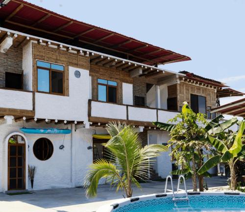 een huis met een zwembad voor een gebouw bij MANGLARALTO BEACH SUITE'S in Montañita