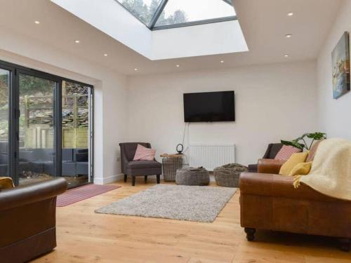 a living room with a couch and a tv at Chambercombe Villa - Harbour View, Decking, Garden, Games Room, sleeps 20 in Ilfracombe