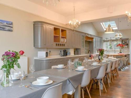 a large kitchen with a long table and chairs at Chambercombe Villa - Harbour View, Decking, Garden, Games Room, sleeps 20 in Ilfracombe