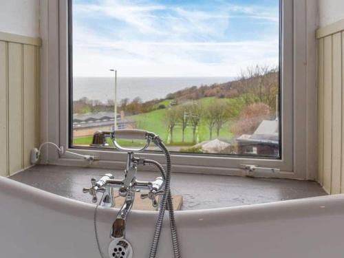 bañera con ducha frente a una ventana en Chambercombe Villa - Harbour View, Decking, Garden, Games Room, sleeps 20, en Ilfracombe