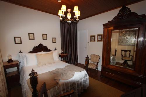 a bedroom with a large bed and a mirror at Quinta da Tapada in Avô