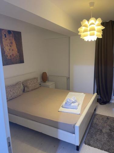 1 dormitorio con cama y lámpara de araña en Tranzzit Airport Apartment II, en Otopeni