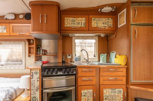 a kitchen with wooden cabinets and a stove top oven at Villaverde Glamping in Villaverde