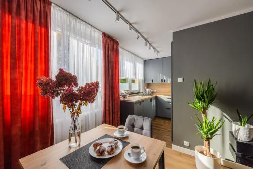 a kitchen and dining room with a table with flowers on it at Apartament Pod Dwójką in Bielsko-Biała