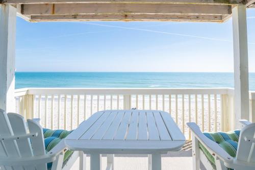 a blue table and chairs on the beach at Oceanfront Condo with 3+ Pools - Ocean Dunes 1701 in Kure Beach