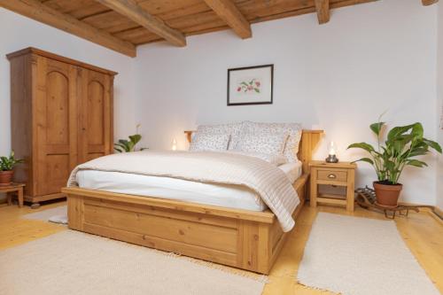 a bedroom with a bed and a wooden cabinet at Kégli apartmanok és fürdőház Hollókő in Hollókő