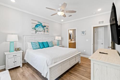 a white bedroom with a bed and a ceiling fan at Pescador Landing A4 in Perdido Key