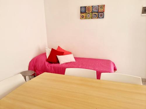 a room with a bed and a table and chairs at Dpto Queen in Caleta Olivia