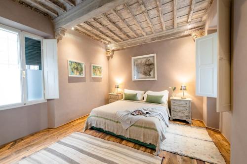 ein Schlafzimmer mit einem großen Bett und zwei Fenstern in der Unterkunft Borgo Signature Rooms in Florenz