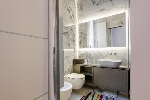a bathroom with a sink and a toilet and a mirror at B&B Liberty Suite Milan in Milan