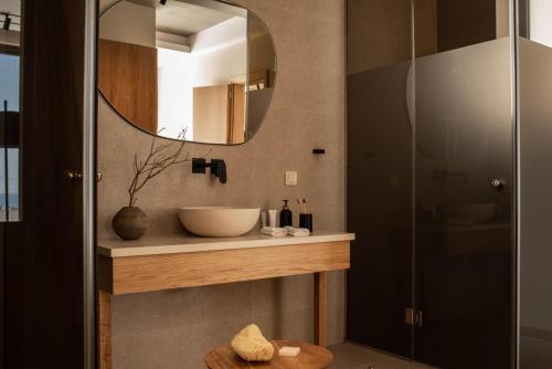 ein Bad mit einem Waschbecken und einem Spiegel in der Unterkunft Limnionas Serenity Cave Villa in Kampíon