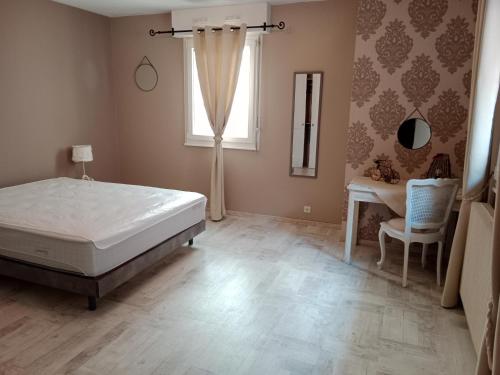 um quarto com uma cama, uma secretária e uma janela em Au répit centre Thermes Luxeuil T3 em Luxeuil-les-Bains