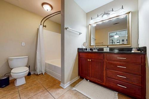 een badkamer met een wastafel, een toilet en een spiegel bij The Pensacola Sanctuary in Pensacola