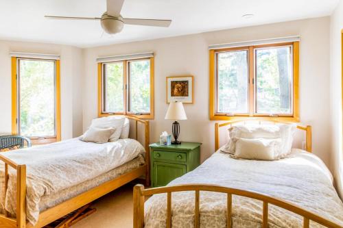 two beds in a room with windows at 2nd Base - Main Home in Sawyer