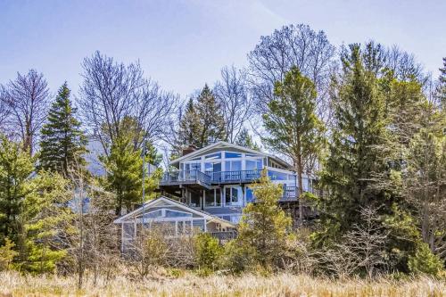 a large blue house in the middle of trees at 2nd Base - Main Home in Sawyer